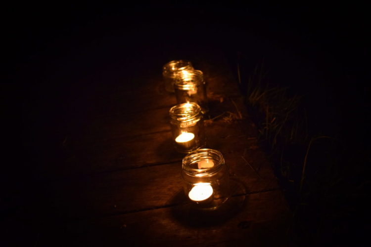 a row of tea light candles in jam jars