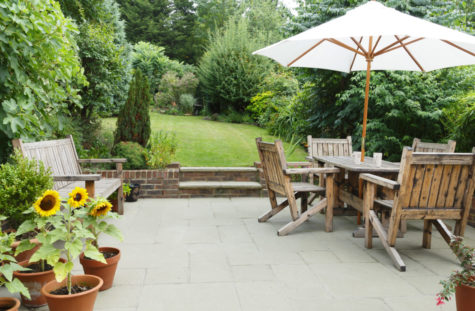 a set of wooden dining furniture on a garden patio