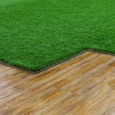 a wooden deck that meets a lush lawn in a zig-zag shape with crisp metal edging