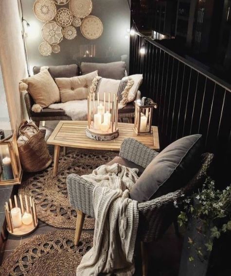 a cosy balcony lit by several clusters of white pillar candles