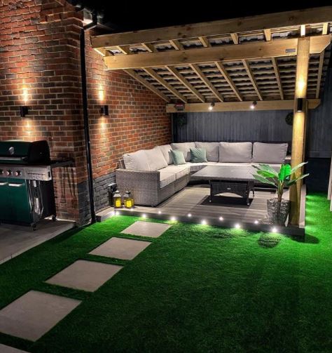 a garden deck under a pergola with spotlights and accent lights