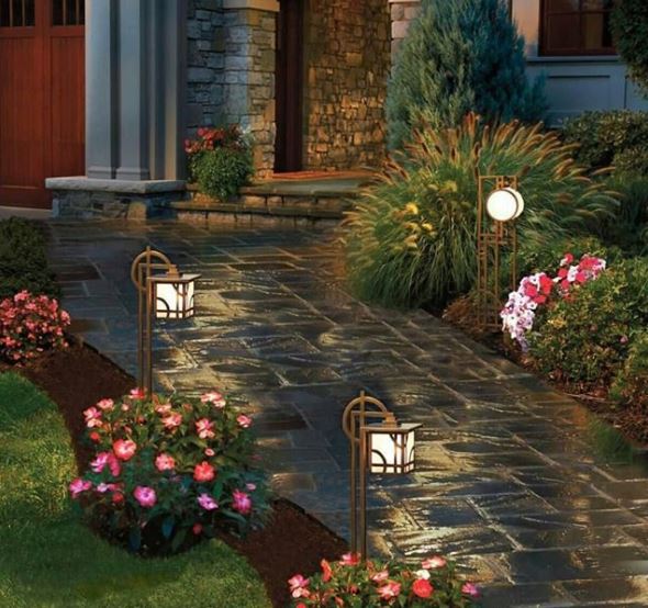Japanese inspired stake lights between flowering shrubs along a stone path
