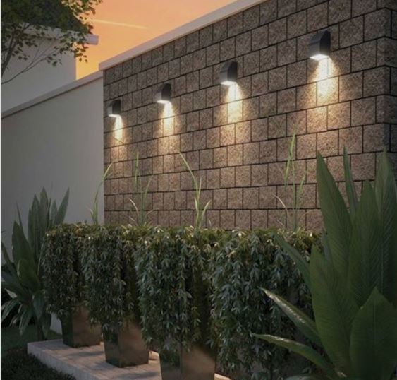 four spotlights along a garden wall, pointing dowards at the bottom plants below, making them look very dramatic
