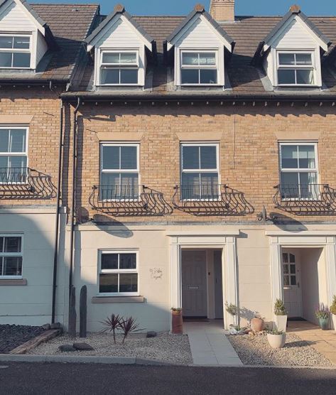 front garden ideas - a gravel garden with sand-coloured pebbles that complement the cream of the house