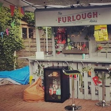 A garden bar with a sign saying the Furlough Arms