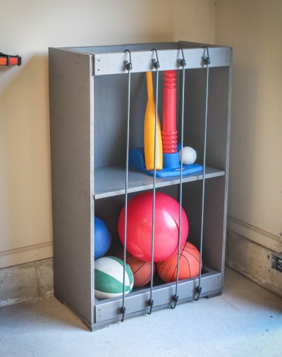 13 Outdoor Toy Storage Ideas for Any Garden Style 11 DIY crate storage with bungees across the front to keep toys in place