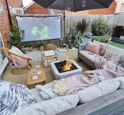 DIY garden cinema with a huge outdoor couch, fire pit and popcorn