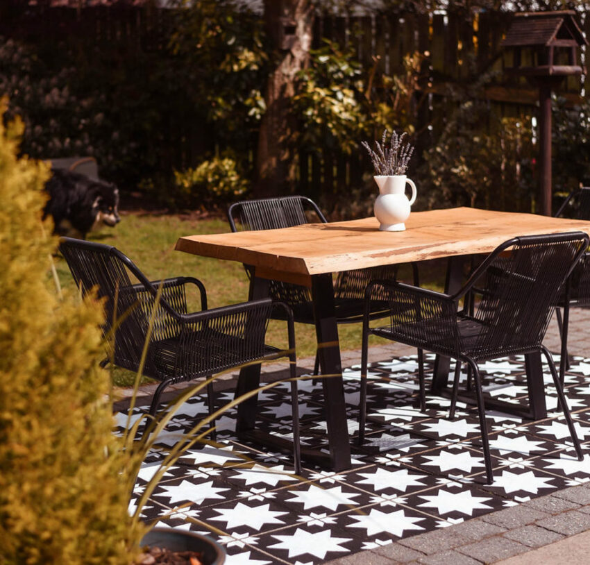 A patio that has been painted to look like black and white tiles