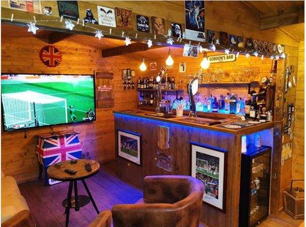 23 Cool Garden Man Cave Ideas to Pimp Your Outdoor Shed 11 a DIY home bar, with pub-style counter, large TV and leather armchairs