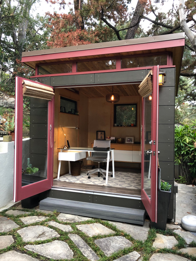 a boxy, modern shed with contemporary desk and shelving inside
