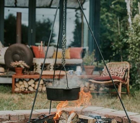 20 Garden Kitchen Ideas For The Perfect Outdoor Cooking Area 16 a fire pit with a pot cooking on a tripod over a flame