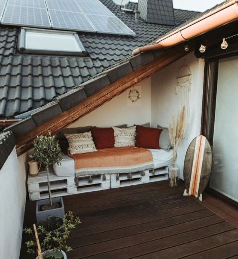 15 Roof Garden Ideas to Design Your City Escape From Chaos 3 a pallet bench with cushions is fitted neatly under a low roof on a balcony