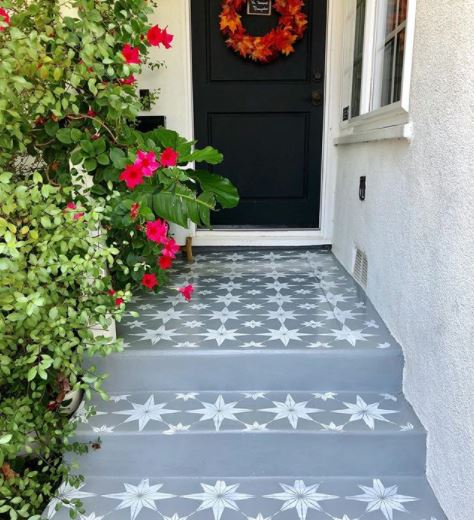 a path and front steps made from painted concrete that's been stencilled to look like tiles