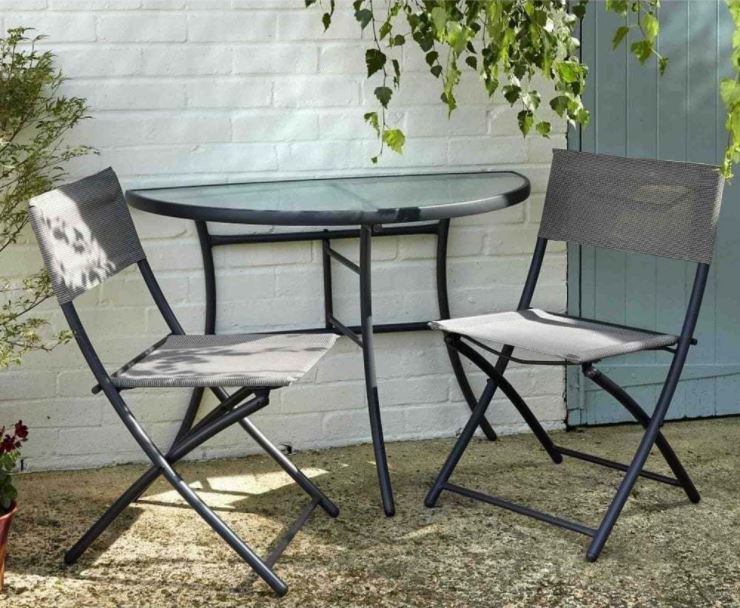 a semicircular table against a wall with two slimline folding chairs