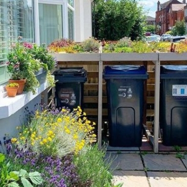 a simple DIY bin cover with a green roof, made from succulents