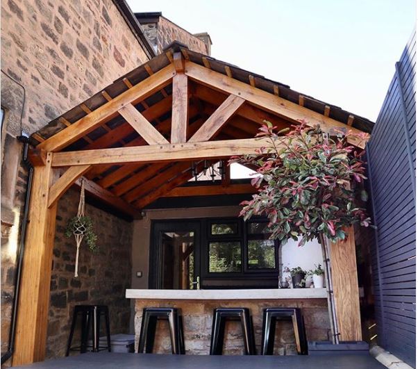a sturdy lean-to extension with a stone bar and pizza oven underneath