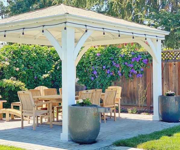 16 Vintage Garden Decor Ideas: Upcycle Glamour to a Garden 12 a sturdy white gazebo with a dining set beneath it and festoon lighting around the outside
