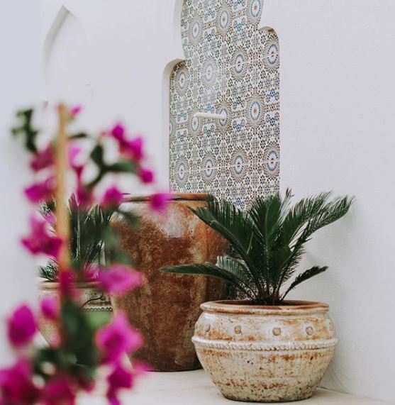 8 Morocco Garden Ideas to Design Your Own Moroccan Courtyard 11 a tiled wall fountain with a spout pouring into a large clay pot below
