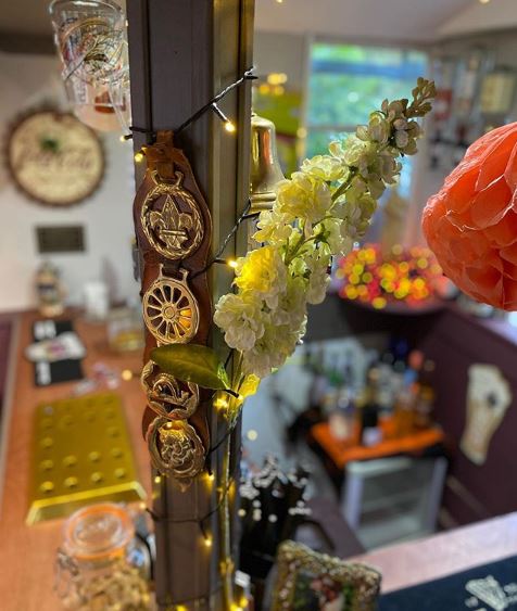a tiny English pub-style bar, with traditional brass medallions displayed next to the counter