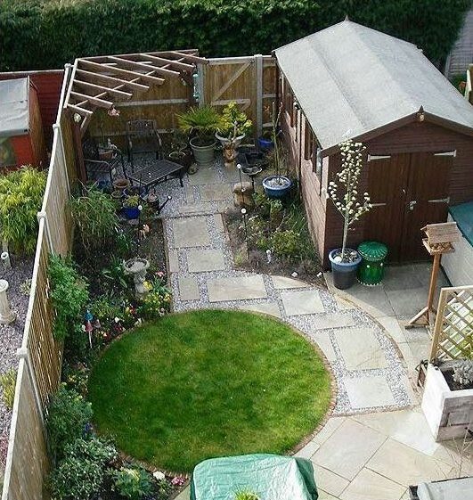a top-down view of a small garden with a carefulyl defined circular lawn