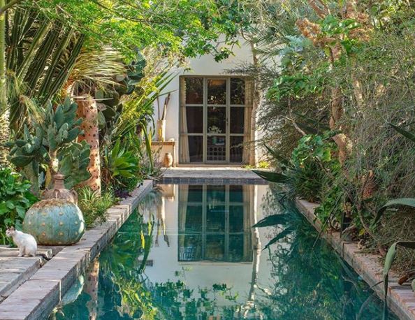 8 Morocco Garden Ideas to Design Your Own Moroccan Courtyard 7 a traditional Moroccan garden with a long, blue pool running down the middle and lots of plants either side