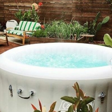 a white inflatable hot tub near a chic wooden sofa and chair set
