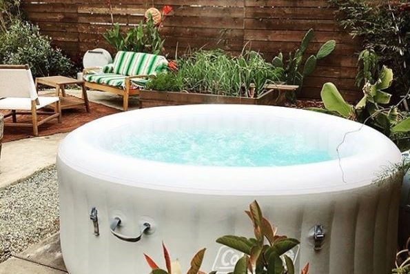 a white inflatable hot tub near a chic wooden sofa and chair set