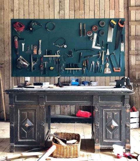 23 Cool Garden Man Cave Ideas to Pimp Your Outdoor Shed 14 a worn antique desk used as a work bench, with an organised tool storage board on the wall behind