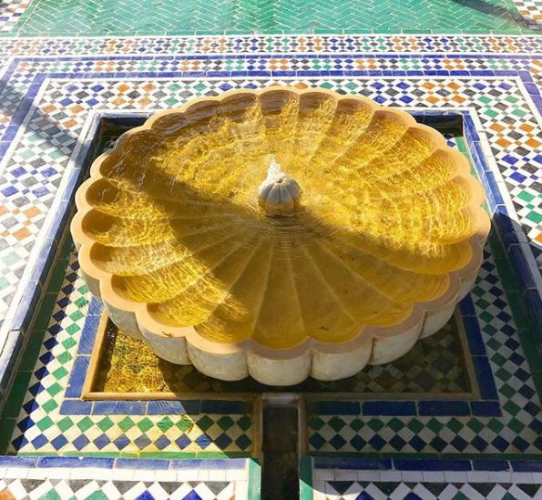 8 Morocco Garden Ideas to Design Your Own Moroccan Courtyard 8 Morocco themed garden ideas using a yellow, flower shaped fountain in a square, beautifully tiled pool
