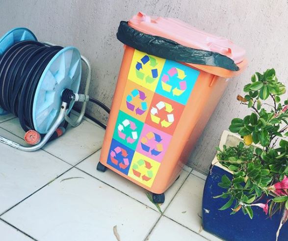 Bin Storage Ideas: How to Hide Your Wheelie Bins and Conceal Your Compost 11 an orange wheelie bin with a decal of multicoloured recycling symbols