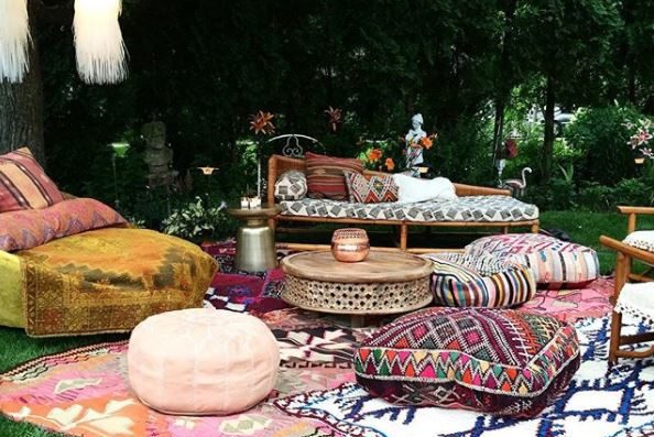 bohemian garden ideas - garden seating laid out on grass with patterend rugs and floor cushions