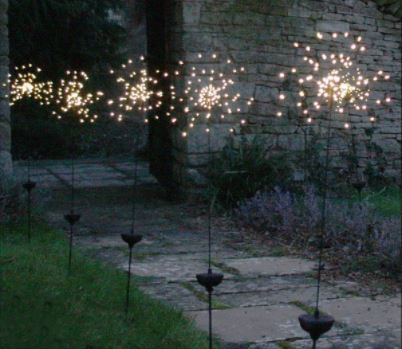 A row of solar powered garden lights that look like dandelions or sparklers
