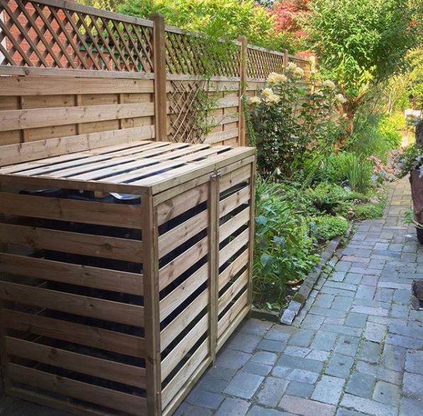 garden bin storage ideas - a bin store made from the same wood as the fence with double doors that bolt closed