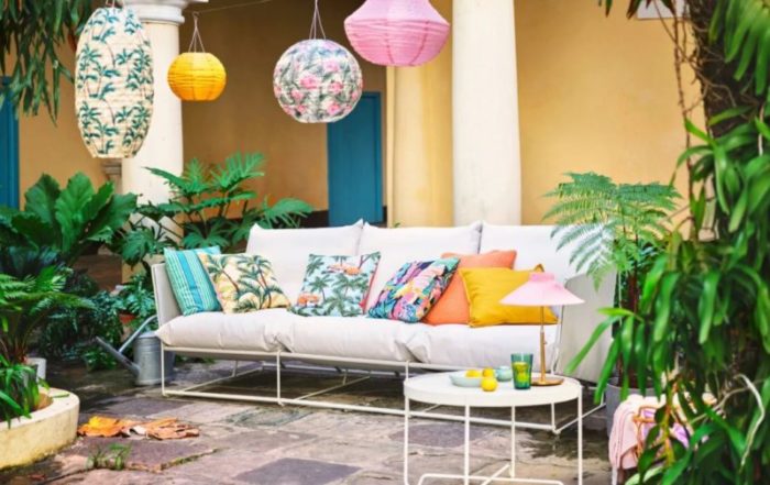 a tropical outdoor seating area with brightly patterned cushions and multi-coloured lanterns