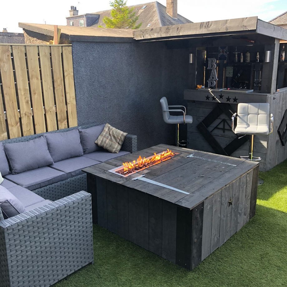 a stylish garden bar with corner sofa and fire pit coffee table