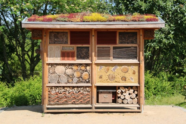 a large insect hotel with various compartments and a green roof