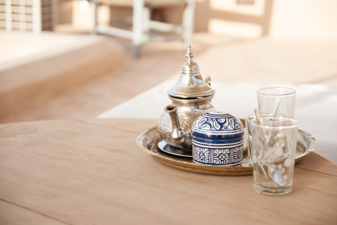 8 Morocco Garden Ideas to Design Your Own Moroccan Courtyard 1 an ornate silver teapot and painted sugar bowl on a clean wooden table