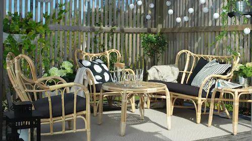 patio furniture in front of a vertical screen, through which the surrounding greenery can be seen