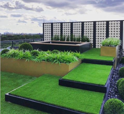 15 Roof Garden Ideas to Design Your City Escape From Chaos 8 rooftop garden ideas - a stylish roof terrace with shallow steps leading up to a hot tub area, covered in artificial grass