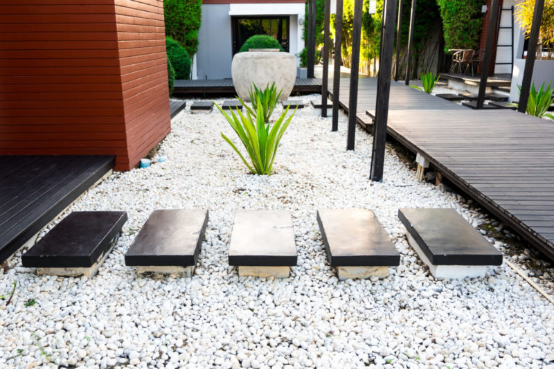 Smooth rectangular stepping stones across a bed of white pea gravel
