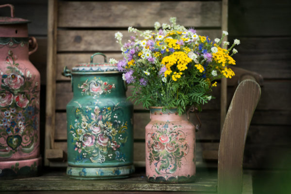 Vintage milk cans painted in pink and green with floral details