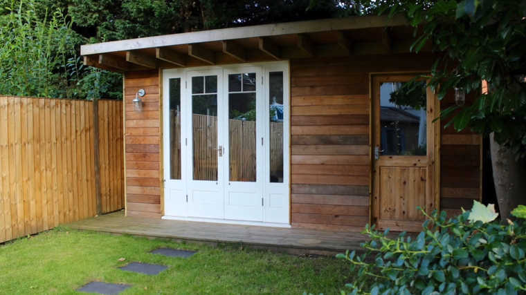 23 Cool Garden Man Cave Ideas to Pimp Your Outdoor Shed 2 the exterior of a man cave shed with a deck at the end of a garden
