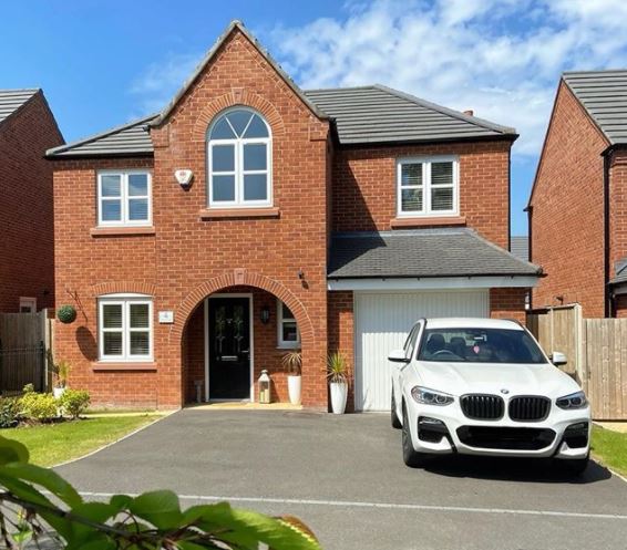 the front of a house with a crisp tarmac driveway that has space for two cars