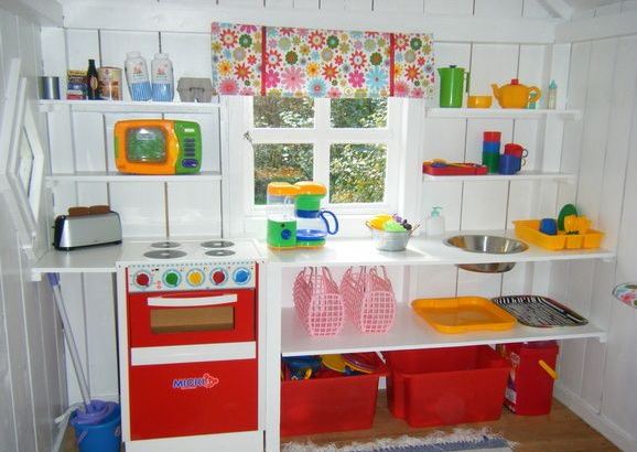 13 Outdoor Toy Storage Ideas for Any Garden Style 7 the inside of a wendy house with shelves for toy kitchenwares and storage boxes