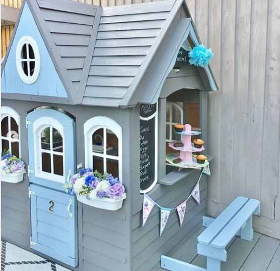 a playhouse decorated as a cake shop with muffins on the windowsill