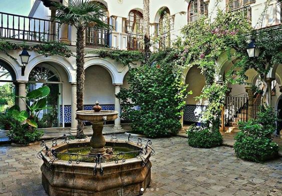 Spanish Themed Garden Ideas: Turn Your Garden into a Sizzling Iberian Sanctuary 8 a traditional Spanish courtyard with fountain, arches and climbing plants