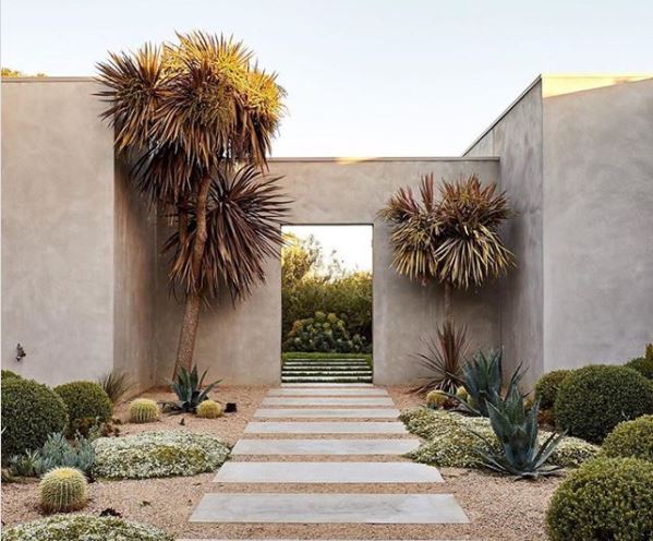 Spanish Themed Garden Ideas: Turn Your Garden into a Sizzling Iberian Sanctuary 4 a gravel garden with drought-tolerant plants and a paved path leading through a stucco arch