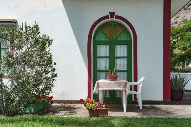 Spanish Themed Garden Ideas: Turn Your Garden into a Sizzling Iberian Sanctuary 9 a white wall with a green door and a red archway painted around it