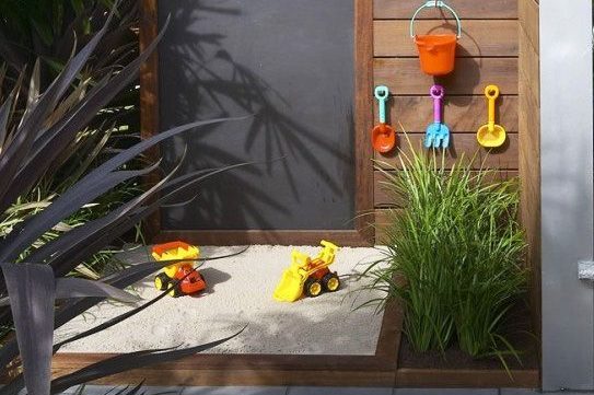 an outdoor sand pit and chalk board for children