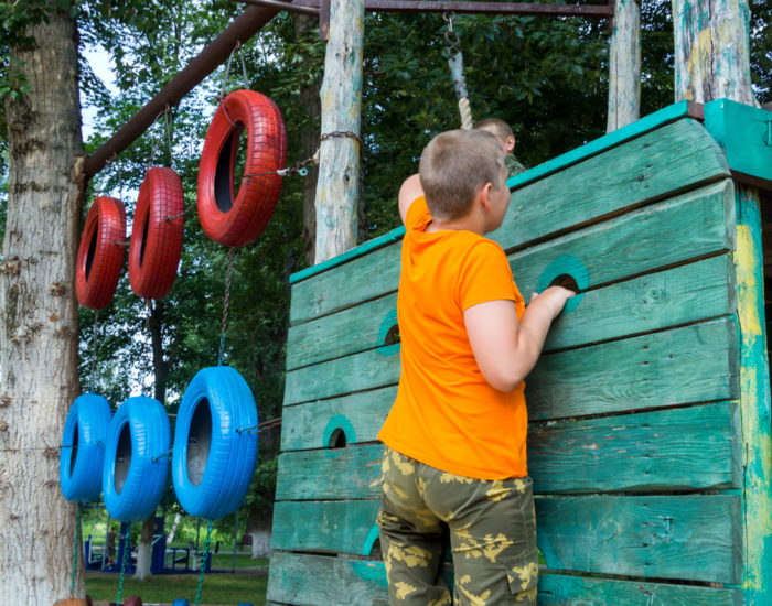 boy on a climbing wall with tyres